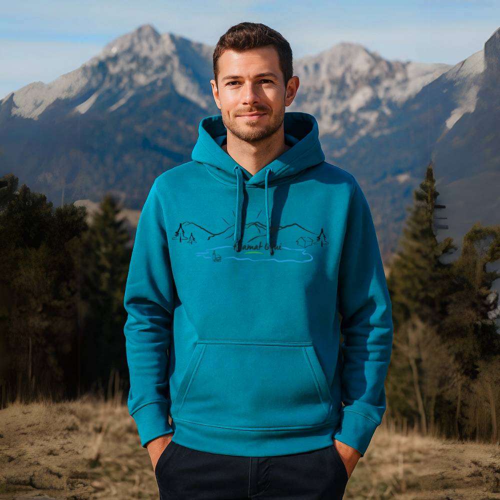 Hoamat Gfui Pullover mit Logo in Blau getragen von einem Mann in den Bergen