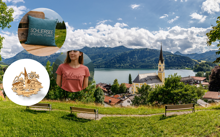 Produkte von Hoamat Gfui mit Blick auf den Schliersee: Kissen mit Koordinaten, T-Shirt „Schliersee Oberbayern“ und Holzmagnet – stilvolle Souvenirs und Geschenke für alle, die am Schliersee einkaufen oder sich Heimat nach Hause holen möchten.